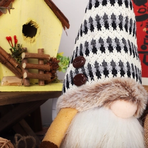 Detail of knitted Christmas gnome with herringbone hat and coffee bean buttons
