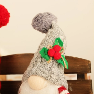 Detail of Christmas gnome showing gray knitted hat with pompom and white beard decor