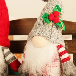 Nordic Christmas gnome with grey knitted hat and red berries on a rustic wood shelf