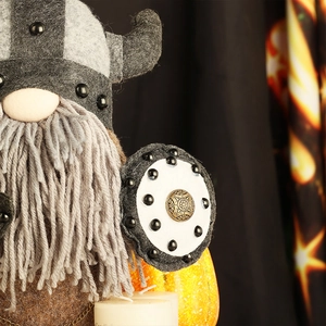 Detail of Viking gnome plush with horned helmet, wool beard, and round shield ornament