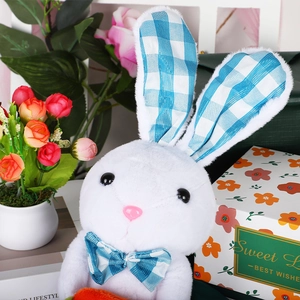 Luminous plush bunny with blue plaid ears holding carrot in a festive gift box setup