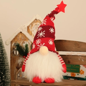 Close-up of lighted Christmas gnome with striped hat and white beard on a wooden bench