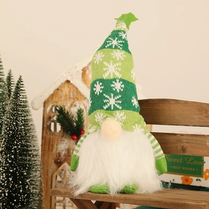 Lighted Christmas gnome plush with green striped snowflake hat on wooden bench