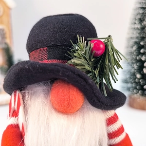 Vue détaillée du gnome de Noël fait main portant un chapeau noir et rouge à carreaux