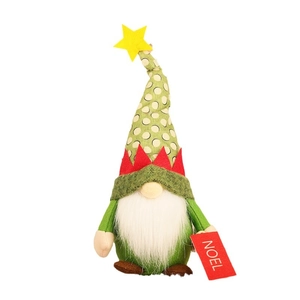 Christmas gnome doll with green polka dot hat holding a Noel sign on white background
