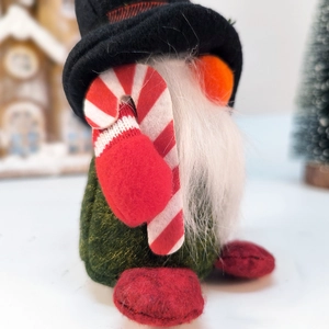 Détail d'un gnome de Noël avec chapeau à carreaux rouges et canne en sucre décorative