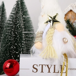 Detailed view of white plush Christmas gnome with gold sequins and hanging star charm