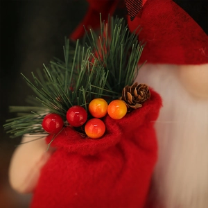 Décoration de Noël avec poche en feutre rouge, aiguilles de pin, baies et pomme de pin