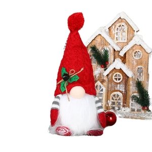 Plush Christmas gnome with lighted red knit hat and white beard on a winter background