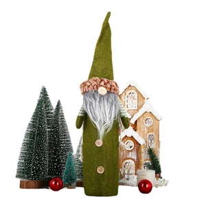 Christmas gnome wine bottle cover with green felt hat and white beard in festive decor