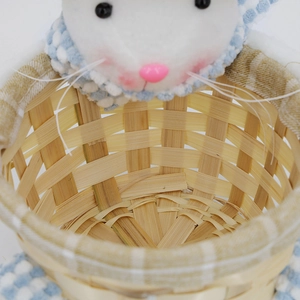 Detail eines geflochtenen Osterkorbs mit Plüschhasenkopf und blau kariertem Stofffutter