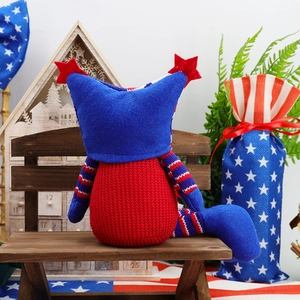 Patriotic gnome doll with USA flag stars and stripes pattern on a rustic wooden bench
