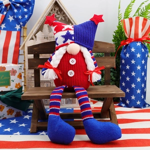 Detail of Independence Day gnome with patriotic hat and long striped legs on mini wooden bench