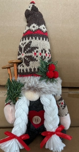 Détail du gnome de Noël avec bonnet en tricot, barbe grise et bâtons de ski en bois