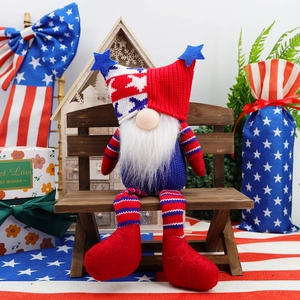 Detail of knit Independence Day gnome doll on wooden bench with patriotic holiday decor