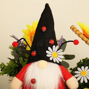 Gnome coccinelle en peluche avec barbe blanche, détail marguerite et ornements en bois