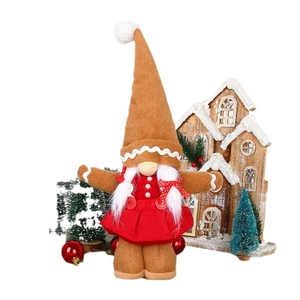 Gingerbread Christmas gnome decoration in red dress with tall pointed hat and braids