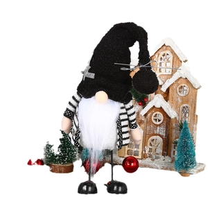 Christmas gnome doll with black striped sweater and sequin star hat on festive background