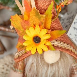 Détail du gnome de récolte montrant un chapeau à chevrons avec érable et tournesol