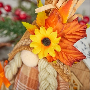 Détail d'un gnome d'automne avec chapeau de paille, tournesol et feuilles d'érable