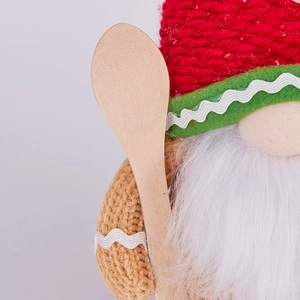 Detailed close-up of Christmas gnome gnome with red knitted hat and wooden spoon