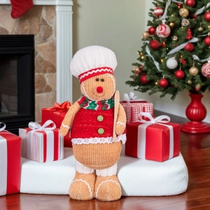Detail of gingerbread chef gnome plush toy with wooden spoon in a Christmas room setting