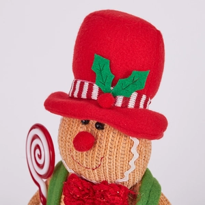 Macro shot of gingerbread gnome plush showing red felt hat and knitting texture details