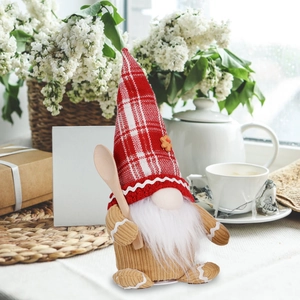 Close-up of a Christmas gnome doll with red plaid hat, white beard and wooden spoon detail