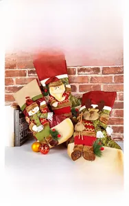 Detail of Christmas stockings with 3D plush Santa, snowman and reindeer figures on red brick