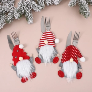 Three Christmas gnome cutlery holders with festive red hats and white beards on a beige background