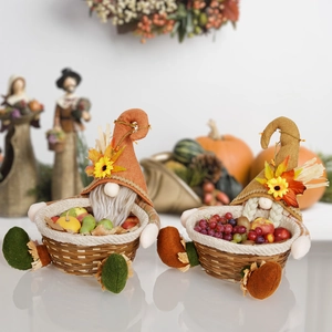 Detail of Thanksgiving gnomes holding woven baskets filled with autumn maple leaves and fruits