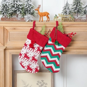 Détail de chaussettes de Noël tricotées rouges et vertes avec motifs rennes et pompons
