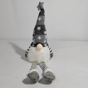 Detail of Christmas gnome plush with gray snowflake hat and striped knit legs