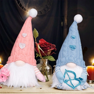 Pareja de gnomos luminosos de San Valentín con arco de Cupido y rosa en mesa de madera