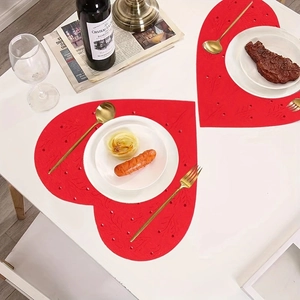 Pair of red heart-shaped placemats with intricate floral patterns for Valentine's Day decor