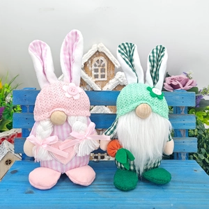 Easter gnome plush dolls with bunny ears and carrots on a blue wooden bench