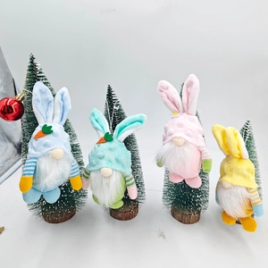 Dettaglio di quattro gnomi pasquali colorati con orecchie da coniglio appesi all'albero