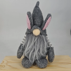 Easter faceless gnome with bunny ears and grey beard on wooden block base
