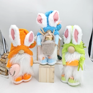 Three plush Easter gnomes with rabbit ears holding a carrot and love egg decor