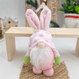 Gnomo pasquale rosa con orecchie di coniglio su panca in legno per decoro festivo