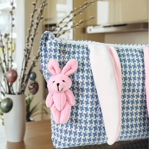 Close-up of blue houndstooth Easter bunny bag with long ears and plush rabbit charm