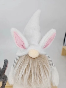 Detail of Easter gnome featuring plush bunny ears on a white hat and long brown beard