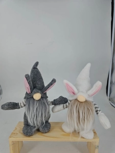 Detail of Easter gnomes with plush rabbit ears and striped arms on wood stand