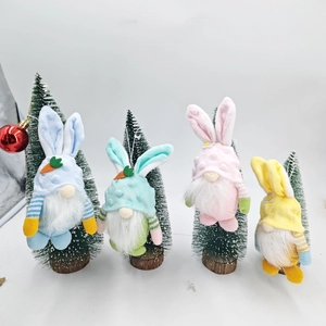 Dettaglio di quattro gnomi pasquali colorati con orecchie di coniglio appesi agli alberi