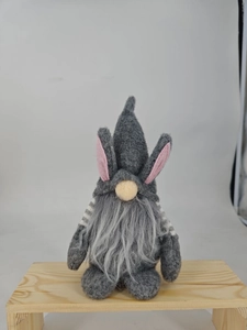 Detail of Easter gnome doll with rabbit ears and plush beard on a wooden display