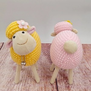 Dettaglio di pecorelle di peluche fatte a mano con tessuto a rilievo e campanellini