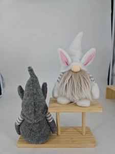 Detail of Easter gnomes with rabbit ears and long beards on a wooden stool