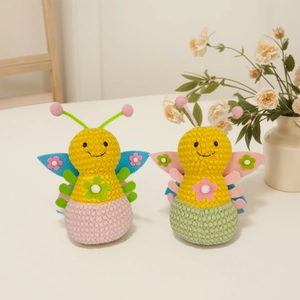Detailed close-up of handmade knitted bee and butterfly dolls with colorful accents