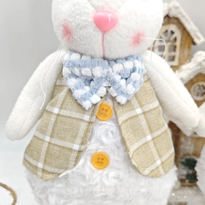 Close-up of white plush bunny doll wearing a brown checkered vest with blue bowtie detail