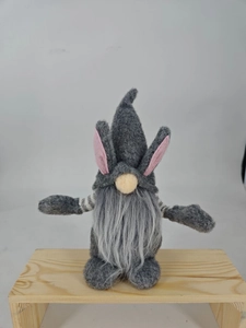 Close-up of Easter faceless gnome with long rabbit ears and grey beard on wooden base